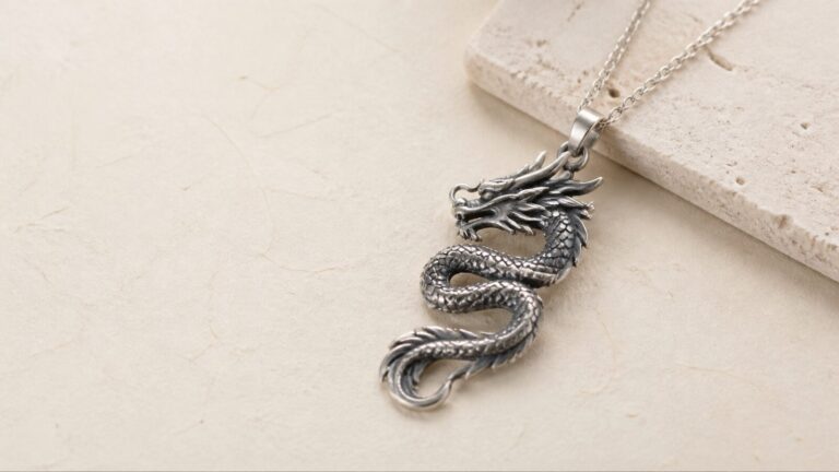 Contemporary coiled dragon pendant in silver on pale stone