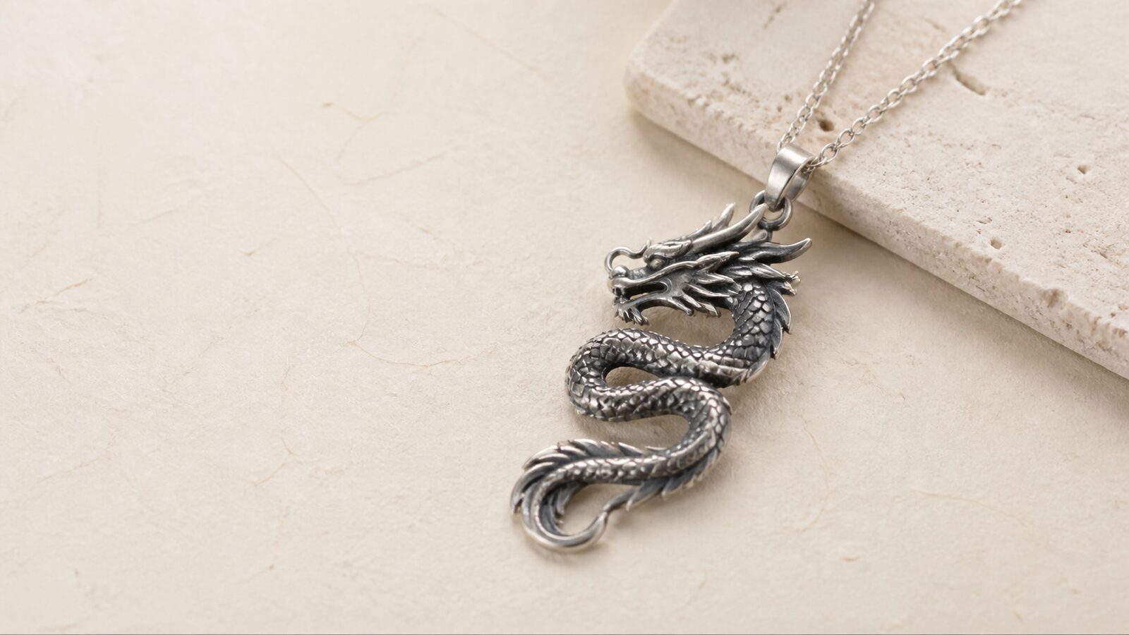 Contemporary silver dragon pendant Contemporary coiled dragon pendant in silver on pale stone