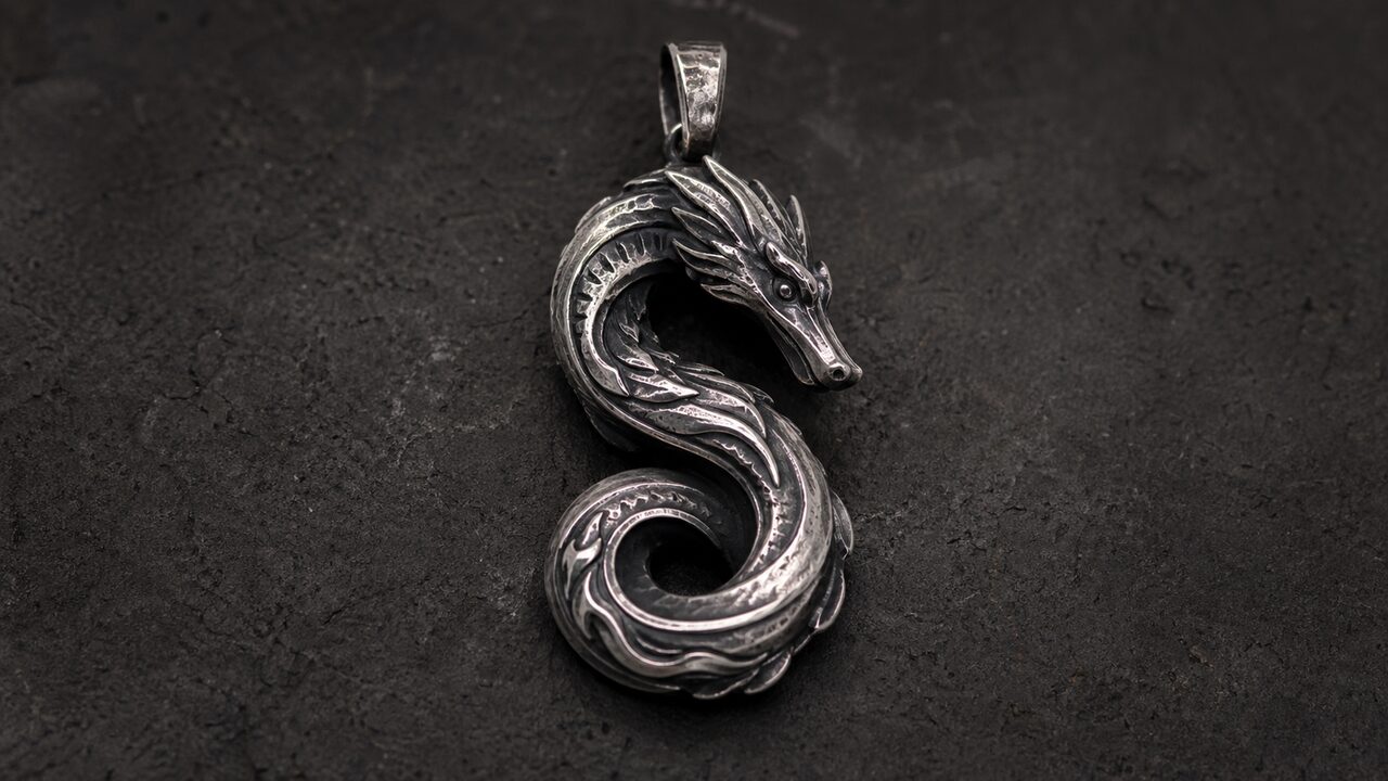 Textural Contrast and Balance - Estovio Oxidized silver Chinese dragon pendant with polished ridges on a dark stone surface